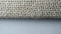 Natural burlap fabric texture with loose weave pattern on neutral background for rustic crafts and eco-friendly packaging design projects.