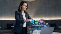 Businesswoman in dark blazer and white shirt interacting with colorful digital app icons floating above laptop, representing software development, technology solutions, and business applications.