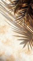 Golden palm leaves casting dramatic shadows on textured beige wall in sunlight, creating minimal tropical aesthetic for modern interior design and decor.
