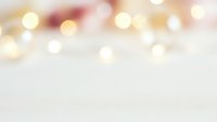 Soft blurred bokeh lights background with warm golden and pink tones creating dreamy atmosphere for holiday celebrations and festive designs.