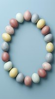 Pastel Easter eggs arranged in an oval frame on a soft blue background, with copy space in the center for text or design.