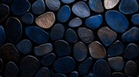 Smooth dark blue and copper river stones arranged in mosaic pattern create dramatic contrast and zen atmosphere, suitable for spa and wellness backgrounds.
