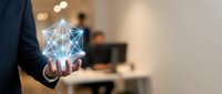 Businessman holding glowing geometric network structure in modern office environment representing digital transformation and connectivity solutions.