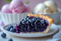 Fresh blueberry pie slice with vibrant purple filling and whole berries on top, served on white plate with ice cream scoops in background, macro food photography.