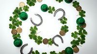 St. Patrick's Day festive arrangement with green shamrock clovers, golden coins, horseshoes and emerald gems on white background for holiday celebrations.