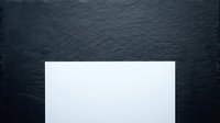 Blank white card on dark textured slate background, isolated mockup for design, branding, stationery, and marketing materials.