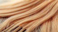 Close-up of blonde hair strands showing texture and natural highlights against soft background, useful for beauty and haircare marketing.