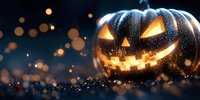 Glowing carved pumpkin with spooky smile on dark background with magical bokeh lights and sparkles creating mysterious Halloween atmosphere.