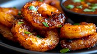Grilled sausages with herbs on dark plate served with green sauce. Barbecue bratwurst links garnished with fresh parsley for outdoor cooking and dining.