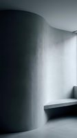Modern minimalist interior with curved concrete wall and floating shelf in monochromatic gray tones creating contemporary architectural space.