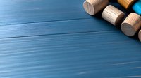 Wooden dumbbells arranged on blue textured wooden background with copy space, fitness and home workout concept for healthy lifestyle.