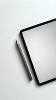 Modern tablet with stylus pen on white textured surface for digital art and design work in minimalist workspace setup.