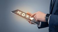 Businessman in dark suit holding tablet displaying glowing health and medical icons, representing digital healthcare, telemedicine, and medical technology solutions for business applications.