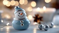 Cute ceramic snowman decoration with knit hat and scarf surrounded by silver ornaments and warm bokeh lights creating festive winter holiday atmosphere.