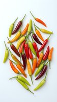 Colorful hot chili peppers scattered on white background. Fresh spicy vegetables in red, orange, yellow and green colors for cooking and seasoning recipes.