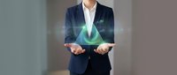 Businessman in dark suit and white shirt holding glowing green leaf hologram, symbolizing sustainability, eco-friendly business practices, renewable energy and environmental responsibility.
