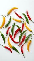 Colorful hot chili peppers in red, yellow and green scattered on white background. Fresh spicy vegetables for cooking and seasoning culinary ingredients.