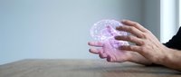 Businessman hands holding glowing purple digital brain hologram representing artificial intelligence, machine learning and neural networks in modern office.