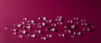 Transparent gel capsules arranged on magenta surface for pharmaceutical, supplement, and healthcare marketing materials.