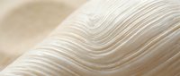 Abstract flowing waves in soft beige and cream tones creating elegant curved lines with smooth gradients for modern design backgrounds and luxury branding.