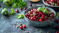 Fresh cranberries and pumpkin seeds in vintage bowl garnished with basil leaves, perfect for healthy eating blogs, recipe websites and seasonal food photography.