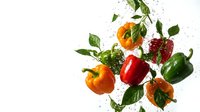 Fresh colorful bell peppers with water droplets and green leaves splashing on white background for healthy cooking and nutrition concepts.