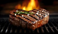 Juicy grilled beef steak with rosemary sprig and sea salt on black grill grate, dramatic lighting with flames in background, close up view of meat texture.