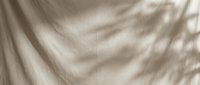 Soft beige fabric texture with natural light and shadow patterns creating elegant drapery folds for interior design and textile backgrounds.