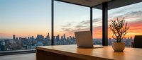 Modern office workspace with wooden desk, laptop, and potted plant positioned near floor-to-ceiling windows overlooking urban skyline at sunset, suitable for corporate and business design projects.