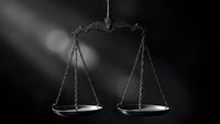 Classic scales of justice in dramatic black and white lighting symbolizing legal system, law enforcement, court proceedings and judicial balance.