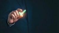Businessman in dark suit holding glowing green checkmark symbol, representing approval, success, and positive business decision-making for corporate concepts.