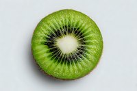 Fresh kiwi fruit slice showing vibrant green flesh and black seeds in circular pattern on white background for healthy eating and nutrition concepts.