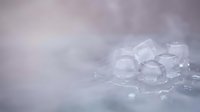 Translucent ice cubes scattered on a frosted surface with soft, diffused lighting creating a cool, refreshing atmosphere suitable for beverage, food, and wellness marketing.