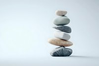 Balanced stack of smooth zen stones in neutral colors against light background, creating harmonious composition for wellness and meditation concepts.
