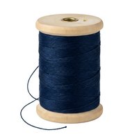 Wooden spool of navy blue thread isolated on white background, ready for sewing, quilting, embroidery, and textile craft projects.