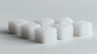 White sugar cubes arranged in rows on plain surface, showing crystalline texture and sparkle under soft lighting, minimalist composition for food and beverage concepts.