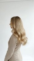Professional blonde businesswoman in beige suit jacket with long wavy hair in profile view against white background for corporate branding materials.