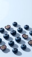 Fresh blueberries arranged in a pattern on white background with some cut in half showing interior. Suitable for food photography, healthy eating content, recipe blogs, and nutritional marketing materials.