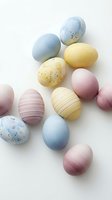 Pastel colored Easter eggs with speckled and striped patterns arranged on white background for spring holiday celebration and seasonal decorating projects.