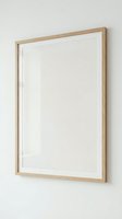 Empty wooden frame with white canvas mounted on neutral wall ready for artwork display and interior design projects.