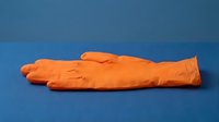 Orange latex glove lying flat on blue surface, isolated and ready for medical, healthcare, safety, or design applications.