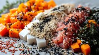 Raw salmon fillet with black and white sesame seeds, diced sweet potato, feta cheese cubes and kale on dark background, healthy cooking ingredients.