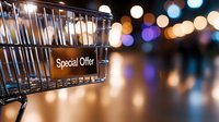 Shopping cart with special offer sign against blurred festive bokeh lights background creating atmospheric retail and seasonal sale ambiance.