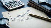 Business growth concept with upward arrow graph drawn on paper, calculator and pen on desk for financial planning and success strategy analysis.