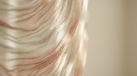 Flowing blonde hair strands with soft highlights catching natural light, showcasing smooth texture and movement for beauty and haircare concepts.