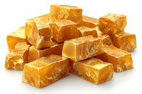 Fresh homemade caramel candy pieces with golden color and soft texture scattered on white background, macro food photography for confectionery marketing.