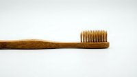 Natural bamboo toothbrush with soft bristles isolated on white background for eco-friendly dental hygiene and sustainable oral care products.