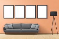 Modern living room interior with gray sofa, black floor lamp and four empty frames on peach colored wall. Wooden floor adds warmth to minimalist design.