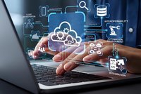 Professional using laptop with cloud computing technology icons and data management interface overlay for digital transformation and business solutions.