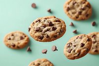 Freshly baked chocolate chip cookies floating on mint green background with scattered chocolate chunks for bakery and dessert marketing materials.